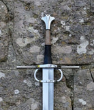 European hand and a half longsword displayed on a stone surface, showcasing its Gothic style and craftsmanship.