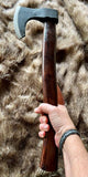 Hand holding a Short Viking Bearded Axe with a leather cover on the blade, displayed on a soft fur background.