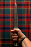 Scottish Long Dirk held against a colorful tartan background, showcasing the Damascus blade and intricate grip.