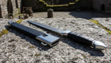 Eastern Dirk displayed on stone surface with leather-wrapped grip and metal sheath, showcasing detailed craftsmanship.