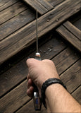 Hand holding an Eastern Dirk with a sleek blade, showcasing fine craftsmanship on wooden surface.