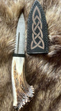 Hand forged sgian dubh with deer antler handle and protective leather sheath, showcasing traditional Scottish craftsmanship.