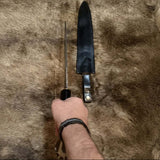 Scottish dirk with crown stag handle displayed alongside its leather sheath on fur background.