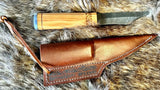 Norse Viking Utility Scramasax Damascus Blade with olive wood handle and leather sheath on fur background.