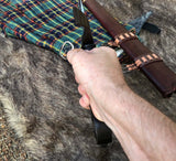 Kern Irish sword held in hand, showcasing the intricate hilt and decorative sheath on a fur background.
