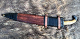 Iberian falcata sword sheath with ornate design, leather straps, and curved handle, displayed on fur background.