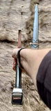 Hand forged Crecy sword held in hand, showcasing its full tang design and medieval craftsmanship.