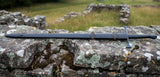 Late Crusader medieval sword displayed on a stone wall, showcasing its hand forged blade and full tang design.