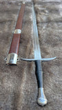 Wakefield knightly bastard sword displayed with its sheath on a textured surface.