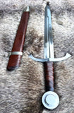 The Bedford Medieval Sword Hilted Dagger displayed with its leather sheath on a textured surface.