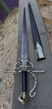 Complex Hilt Sword and Buckler Shield Combo showing a detailed sword with a pointed blade and elegant hilt on a wooden surface.