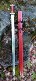 Migration Era Sword with sheath displayed on a rocky surface, showcasing 5th-century design.