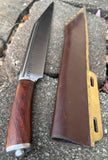 Troll's Bane Runic Viking Seax Knife with leather scabbard laid on stone surface.