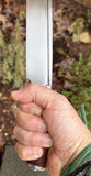 Troll's Bane Runic Viking Seax Knife held firmly in hand, showcasing its sharp blade and craftsmanship.