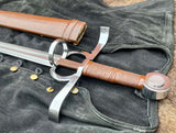A close-up of the Renaissance Battle Sword handle and guard, featuring a wooden handle with a metal guard and a flat diamond grind on the blade.