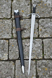 Arming sword with sheath on a stone surface