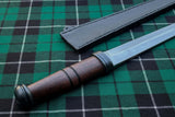 Irish Scian (Dirk) displayed on a green tartan background with leather sheath.